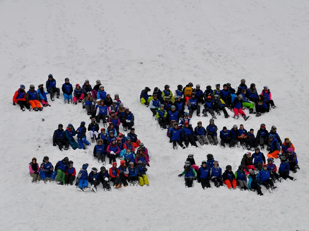 Große Gruppe formt im Schnee die Zahl 35.